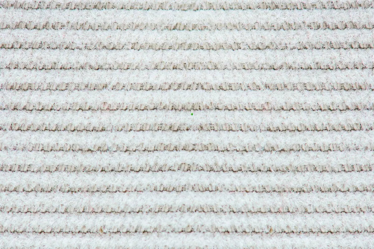 Close view of the looped texture of a clean cream carpet