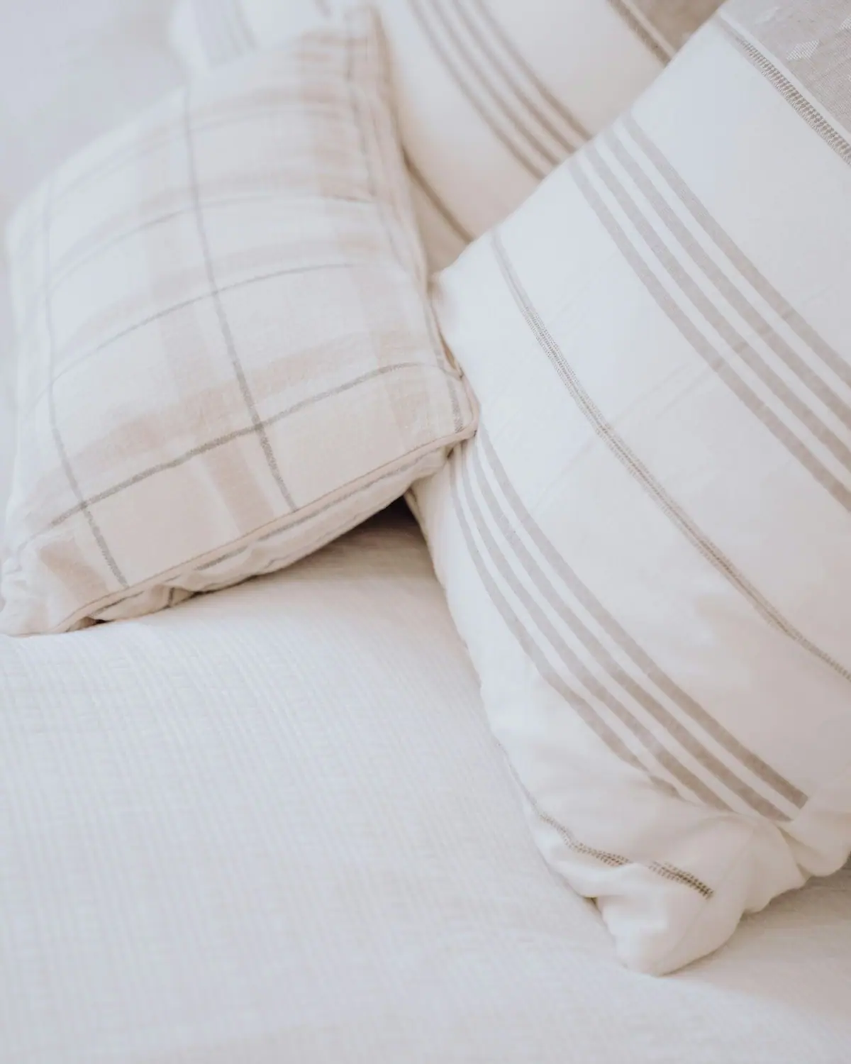 Striped linen pillows on a crisp white sofa