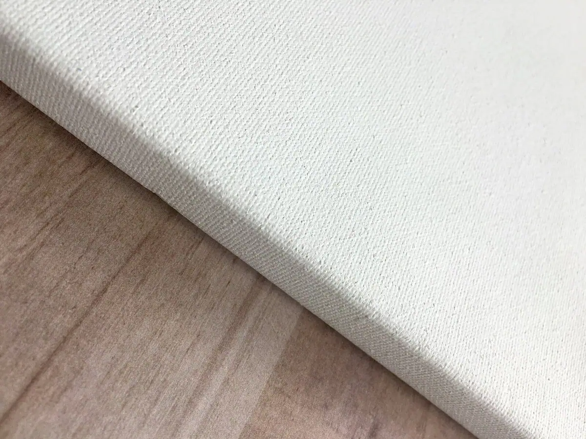 White wool rug on a warm wood floor in a quiet room